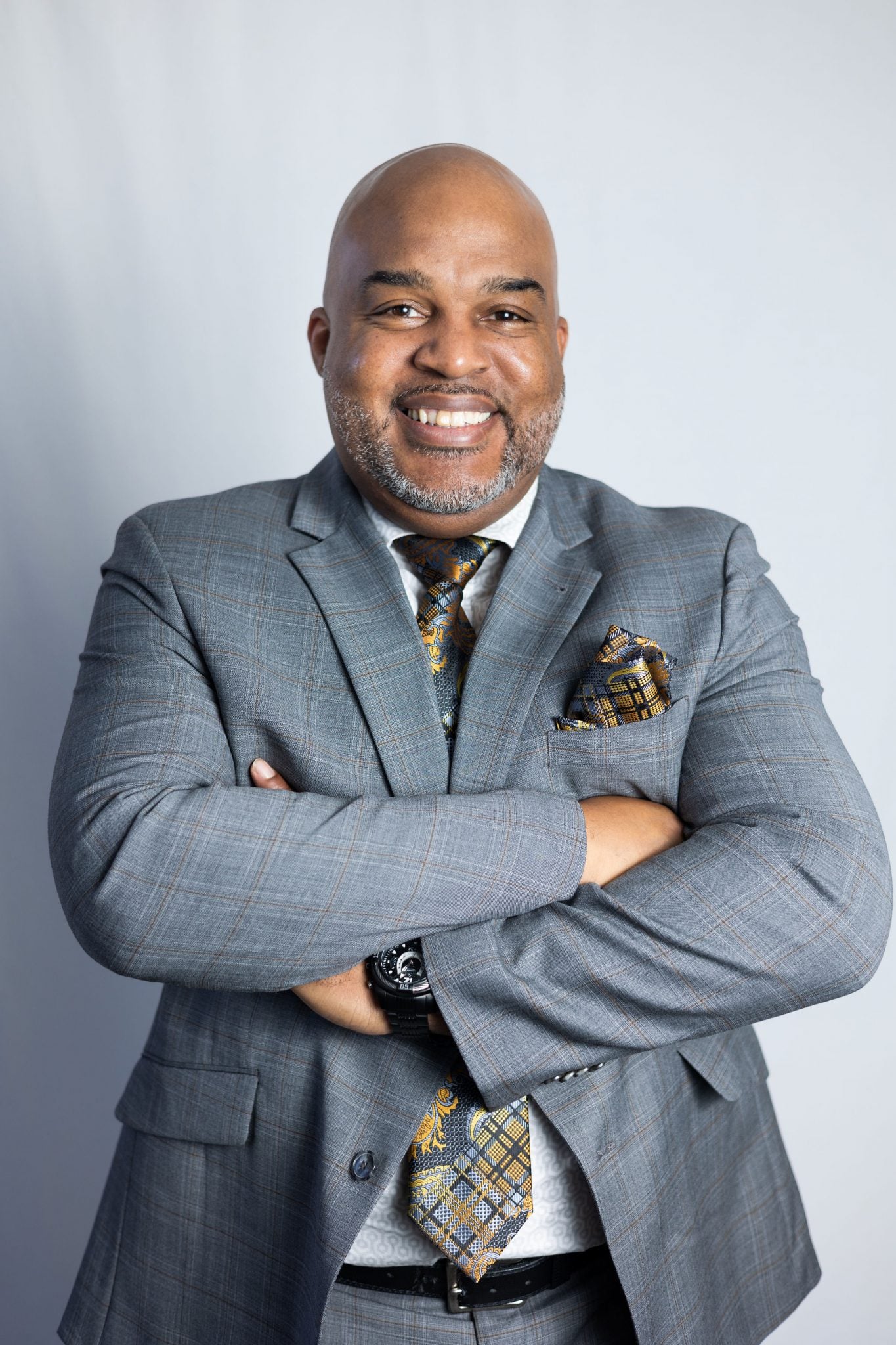 Picture of Pastor Eugene C. McCowan, Jr. standing against a light gray backdrop, facing forward, with arms folded and crossed.